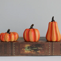 Set de 3 citrouilles décoratives en résine sur un livre ancien
